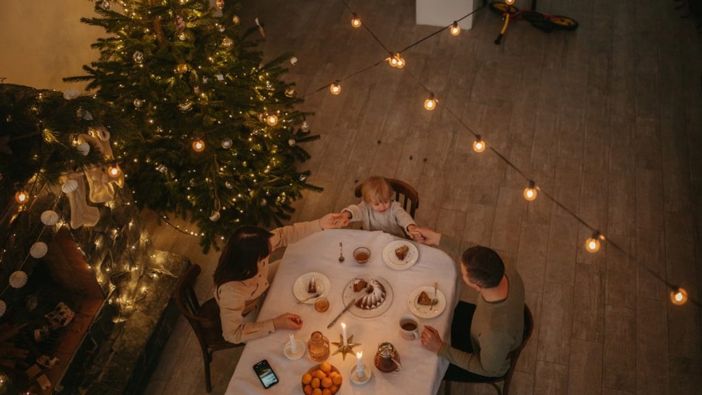 A warm family dinner setting with a Christmas tree and festive lights, capturing the holiday spirit.